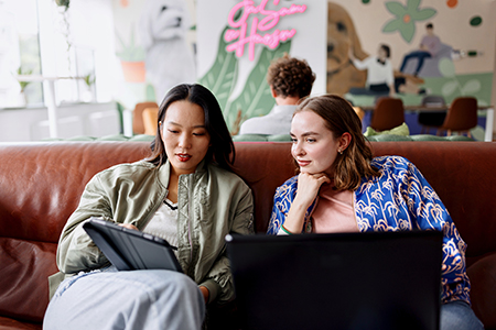 Two social media marketers working side by side in a modern office