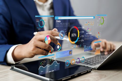Person in a blue suit at a laptop conducting data science experiments with charts and graphs hovering in the air